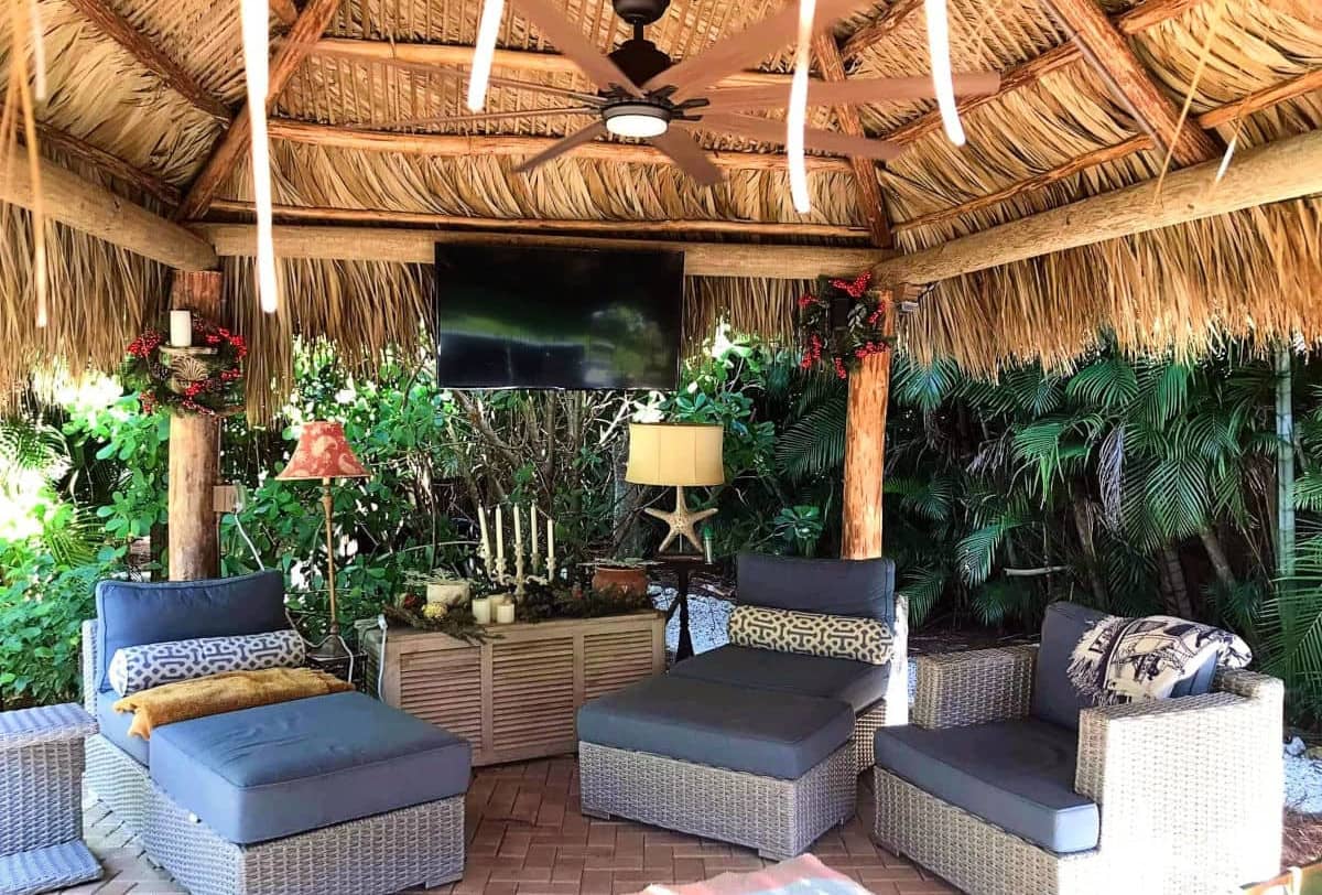 Comfortable tiki relaxing area built with a TV and exterior furniture.