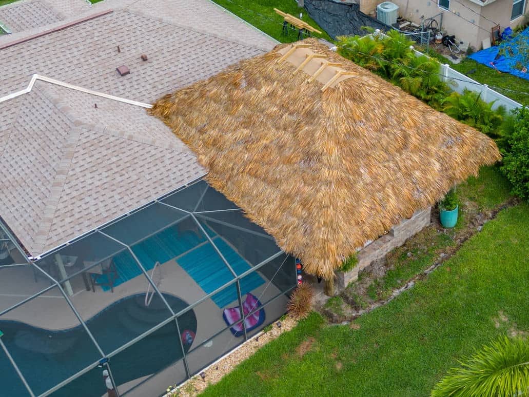 Aerial drone view of a tiki hut built on the corner of a house.