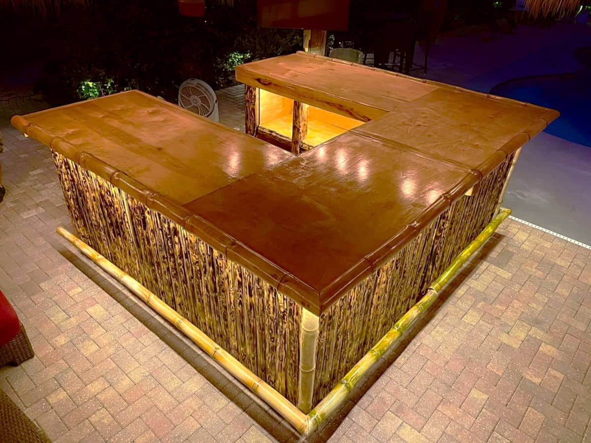Wooden tiki bar with lighting under the edge.