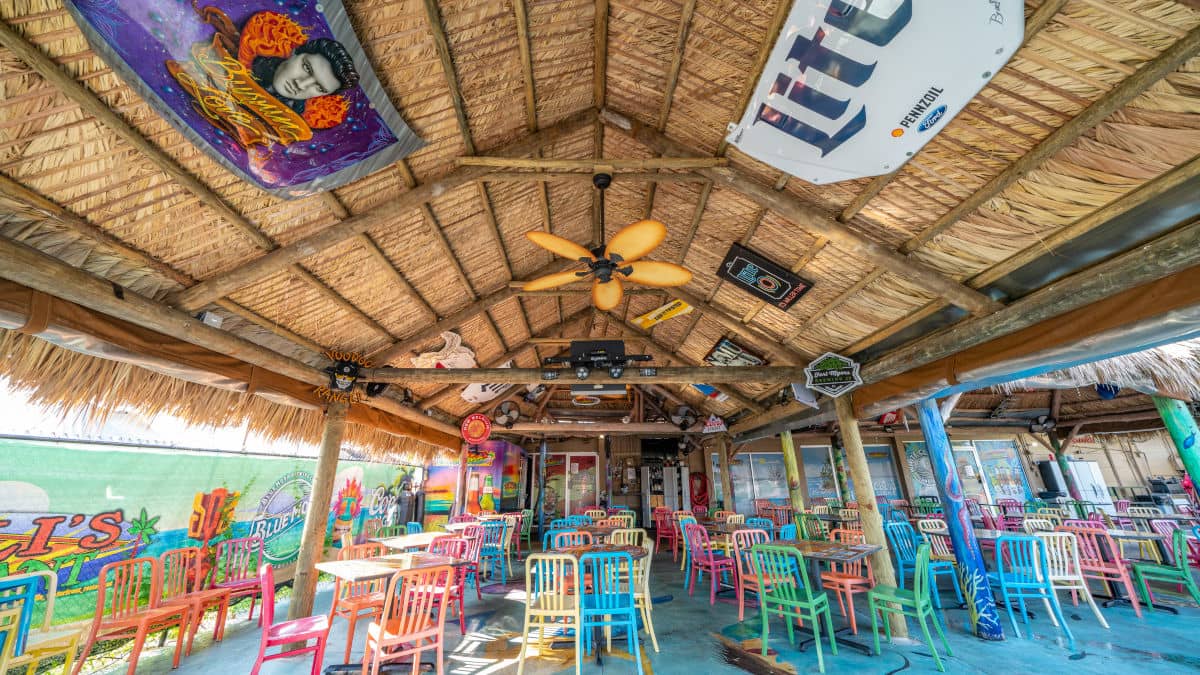 Miceli's restaurant seating area outside under a decorated, large, tiki hut.